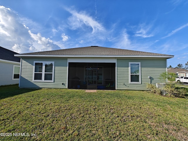 rear view of house with a lawn and a sunroom