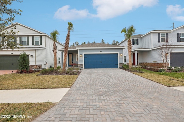 view of property featuring a garage and a front lawn