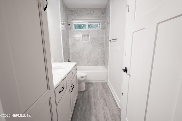 full bathroom featuring vanity, toilet, wood-type flooring, and tiled shower / bath