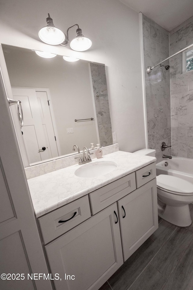 full bathroom with hardwood / wood-style floors, vanity, toilet, and tiled shower / bath combo