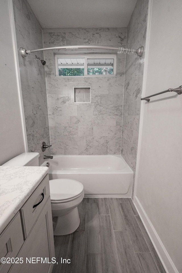 full bathroom with toilet, vanity, and tiled shower / bath combo