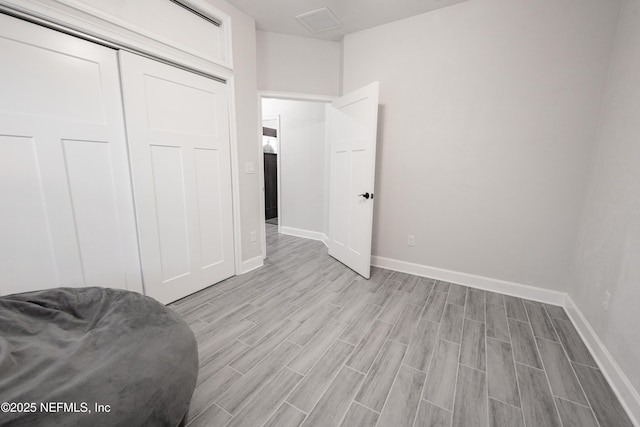 bedroom with light hardwood / wood-style floors and a closet