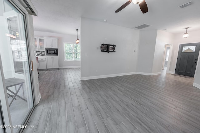 unfurnished living room featuring light hardwood / wood-style floors and ceiling fan