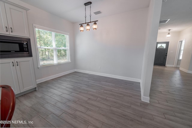 unfurnished dining area with a notable chandelier