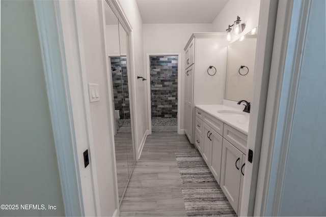 bathroom featuring a tile shower and vanity