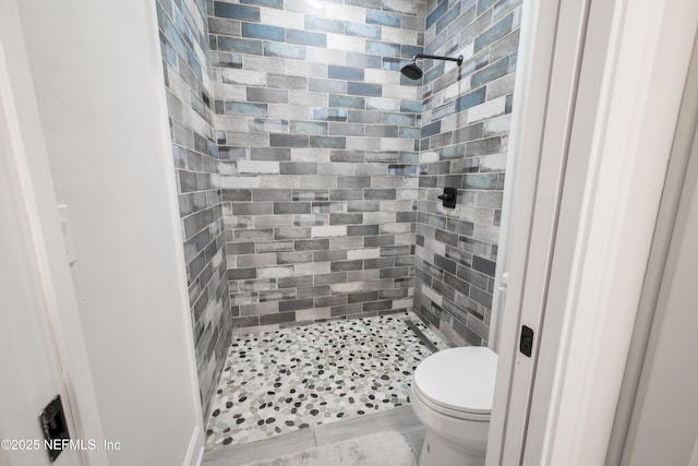 bathroom featuring toilet and tiled shower