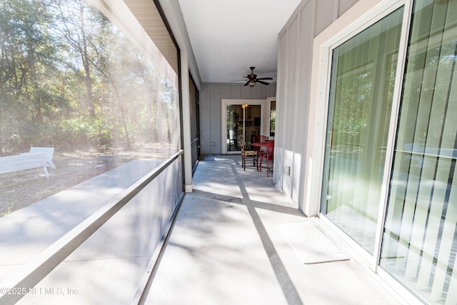 unfurnished sunroom featuring ceiling fan and a wealth of natural light