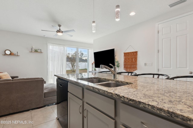 kitchen with sink, hanging light fixtures, gray cabinets, black dishwasher, and light stone counters