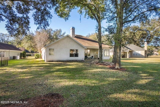 rear view of property with a yard and central air condition unit