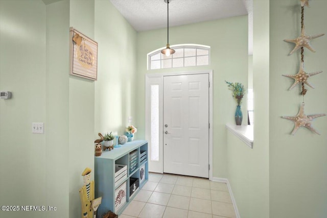 foyer entrance with light tile patterned flooring and a textured ceiling