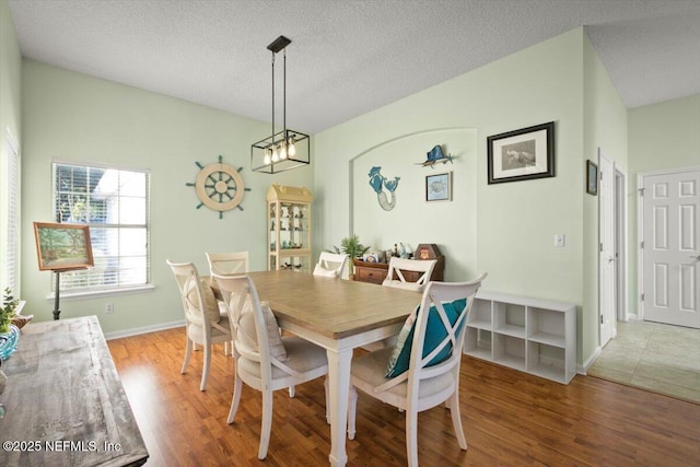 dining room with hardwood / wood-style flooring and a textured ceiling