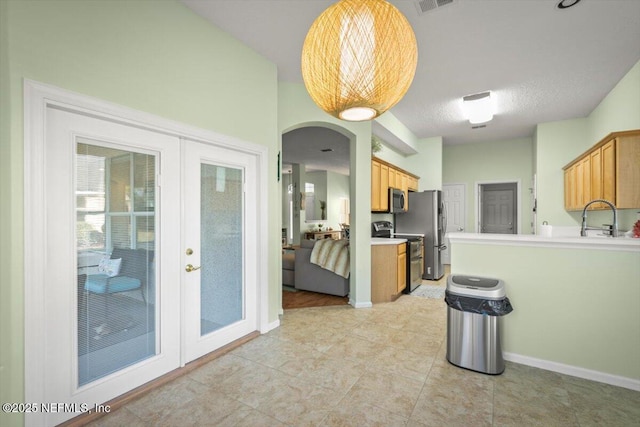 kitchen with appliances with stainless steel finishes, sink, hanging light fixtures, a textured ceiling, and french doors