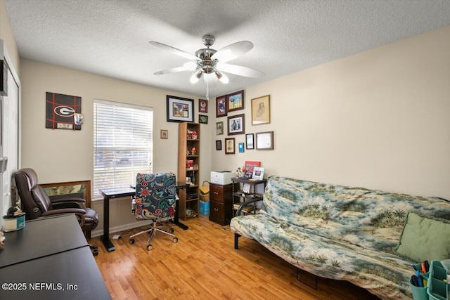 office space with ceiling fan, a textured ceiling, and light hardwood / wood-style flooring