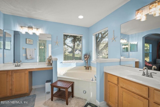 bathroom featuring a tub to relax in, tile patterned flooring, and vanity