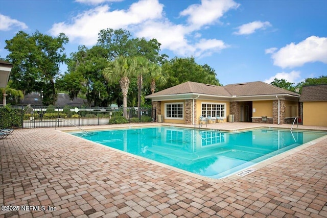 pool with a patio area and fence