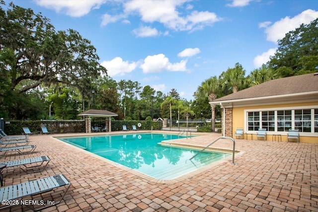 pool featuring fence and a patio