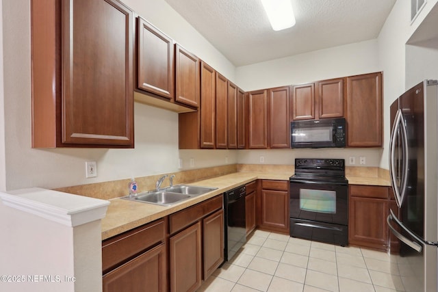 kitchen featuring black appliances, light countertops, a sink, and light tile patterned flooring