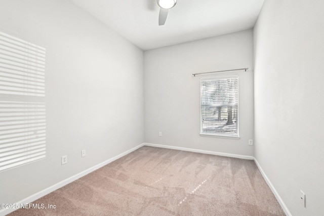 carpeted empty room with baseboards and a ceiling fan