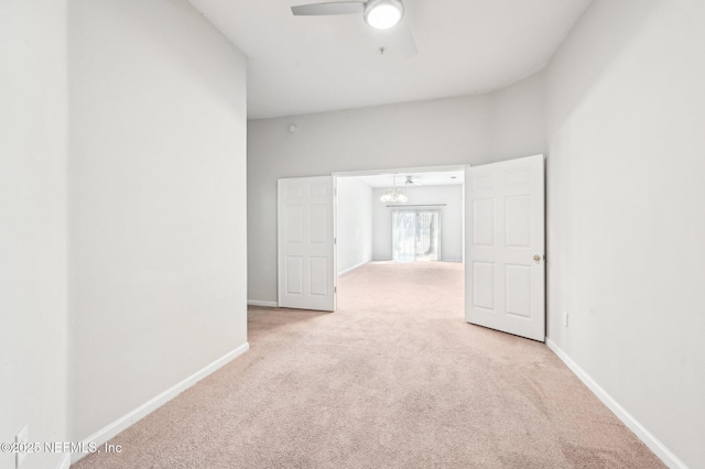 empty room with light colored carpet, baseboards, and ceiling fan with notable chandelier