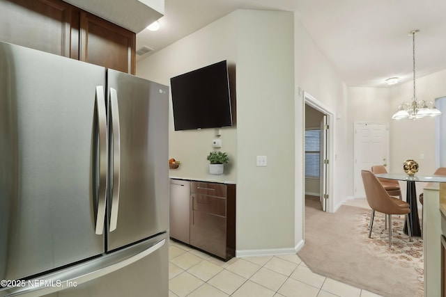 kitchen featuring a notable chandelier, light tile patterned floors, light countertops, visible vents, and freestanding refrigerator