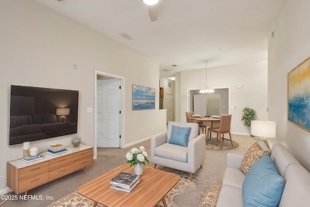 living area featuring baseboards, an inviting chandelier, visible vents, and light colored carpet