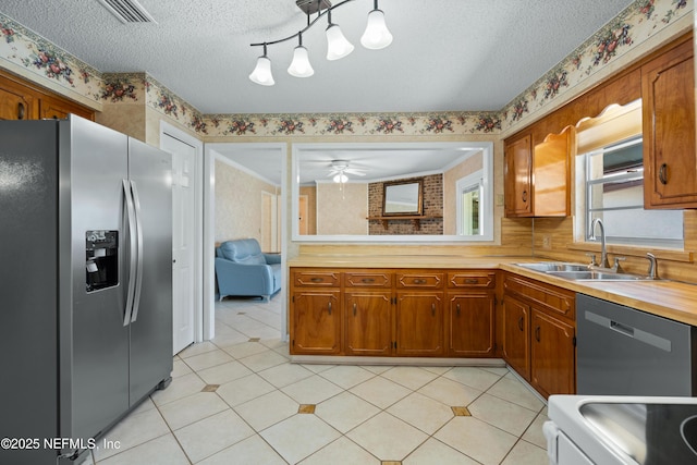 kitchen featuring ceiling fan, sink, a textured ceiling, and appliances with stainless steel finishes