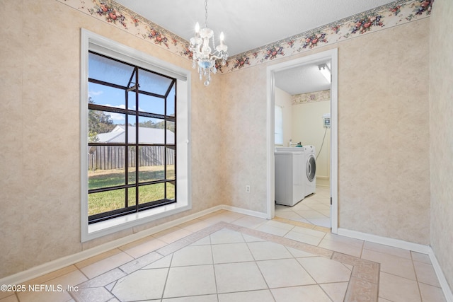 unfurnished dining area featuring washer / dryer, light tile patterned floors, a wealth of natural light, and a chandelier