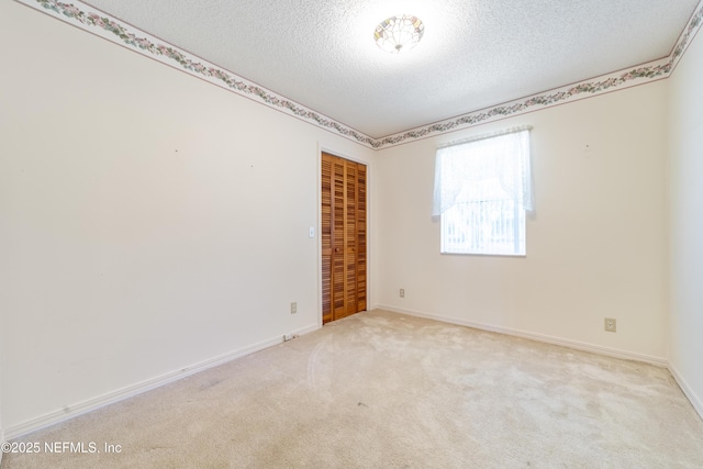 carpeted spare room featuring a textured ceiling