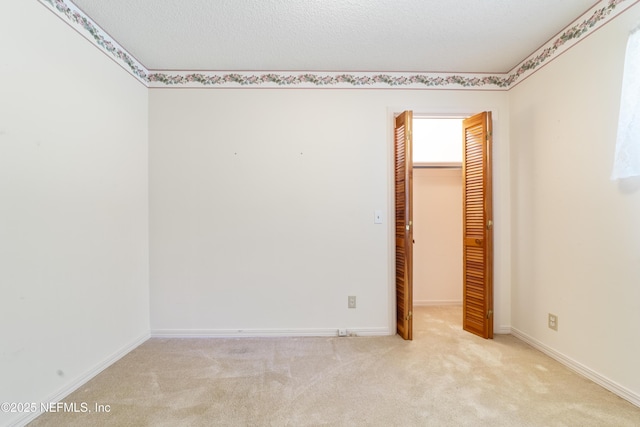 carpeted spare room featuring a textured ceiling