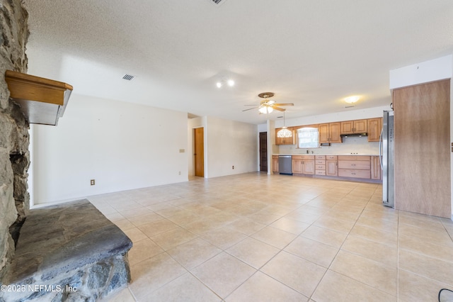 unfurnished living room with ceiling fan, a textured ceiling, and light tile patterned floors