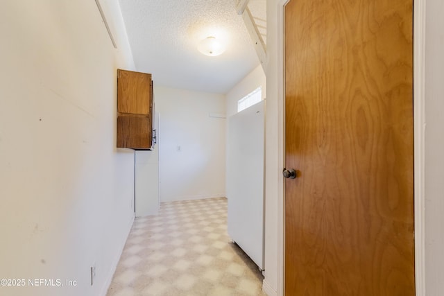 hall featuring a textured ceiling