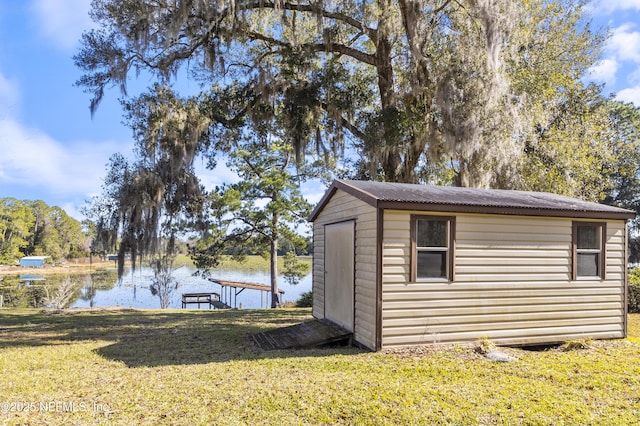 view of outbuilding with a yard and a water view