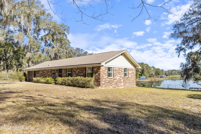 view of property exterior with a yard and a water view