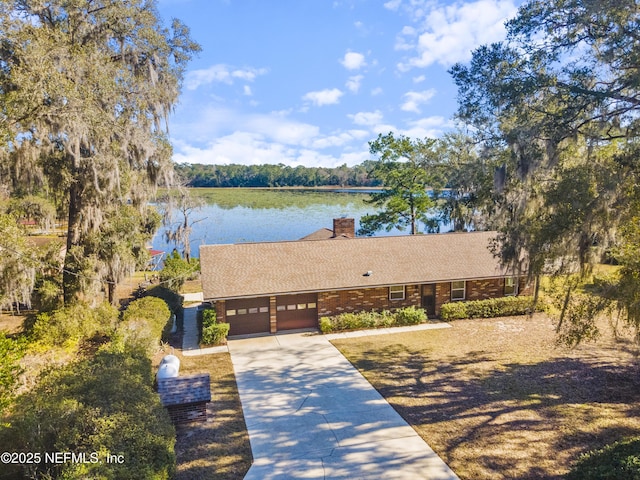 view of front of property featuring a garage and a water view