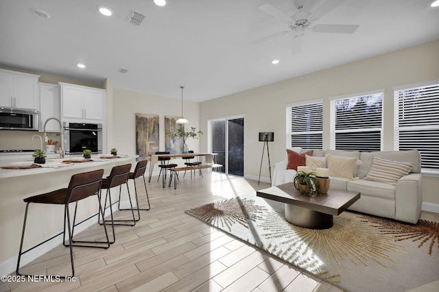 living room featuring light wood-type flooring and ceiling fan