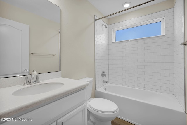 full bathroom with vanity, tiled shower / bath combo, and toilet