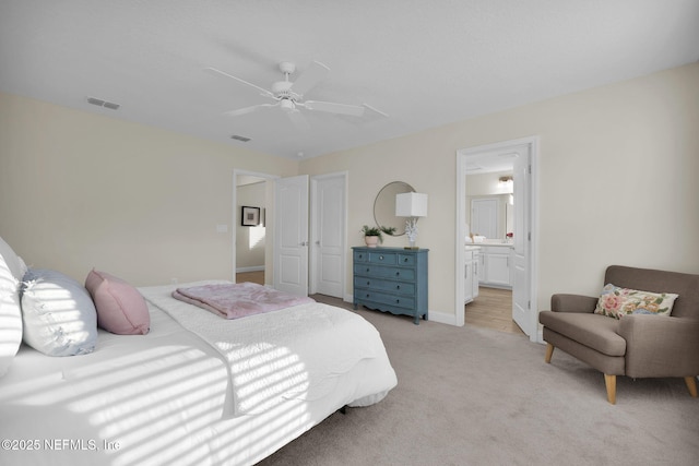 bedroom with light carpet, connected bathroom, and ceiling fan