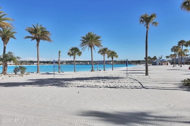 view of pool featuring a water view, volleyball court, and a beach view