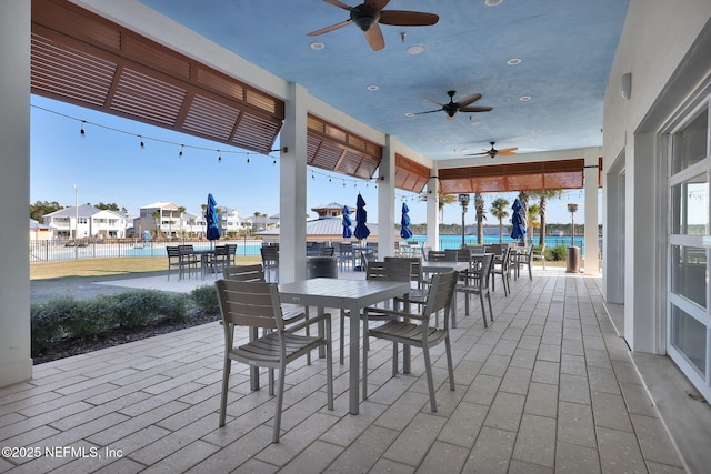 view of patio featuring a water view and ceiling fan