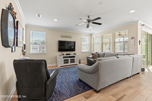 living room with ceiling fan, a healthy amount of sunlight, and ornamental molding