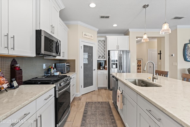 kitchen featuring white cabinets, crown molding, sink, and stainless steel appliances