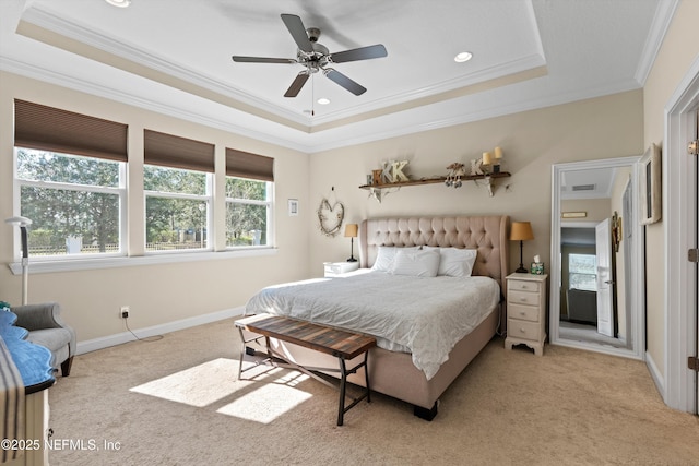 bedroom featuring light carpet, a tray ceiling, ceiling fan, and ornamental molding