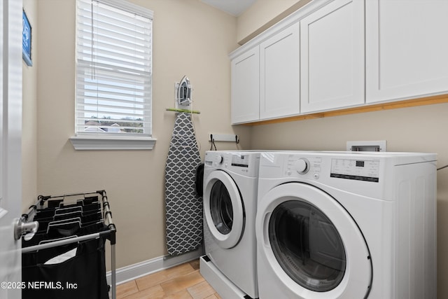 clothes washing area with cabinets and independent washer and dryer