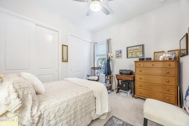 bedroom featuring multiple closets, carpet floors, and ceiling fan