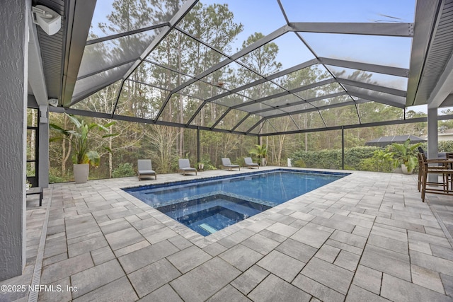 view of pool with an in ground hot tub, a patio, and a lanai