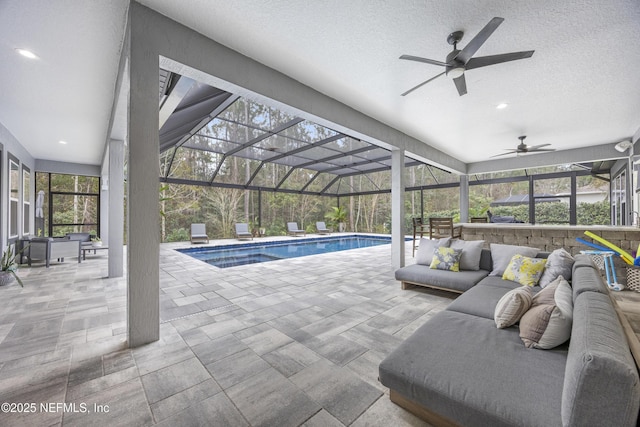 view of pool with ceiling fan, a patio, a lanai, and an outdoor hangout area