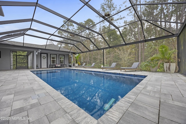 view of swimming pool with a patio area and a lanai