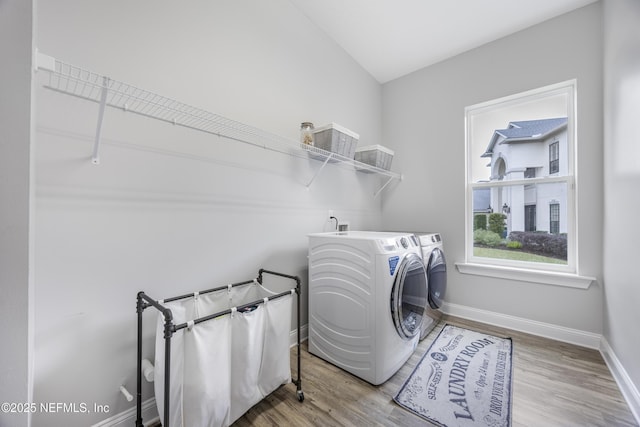 laundry room with washing machine and clothes dryer and wood-type flooring