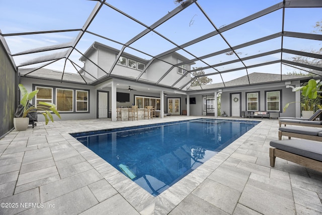 view of pool featuring a lanai, a patio, an outdoor bar, and ceiling fan