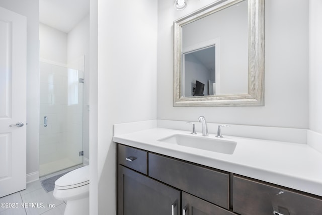 bathroom with toilet, tile patterned flooring, a shower with shower door, and vanity